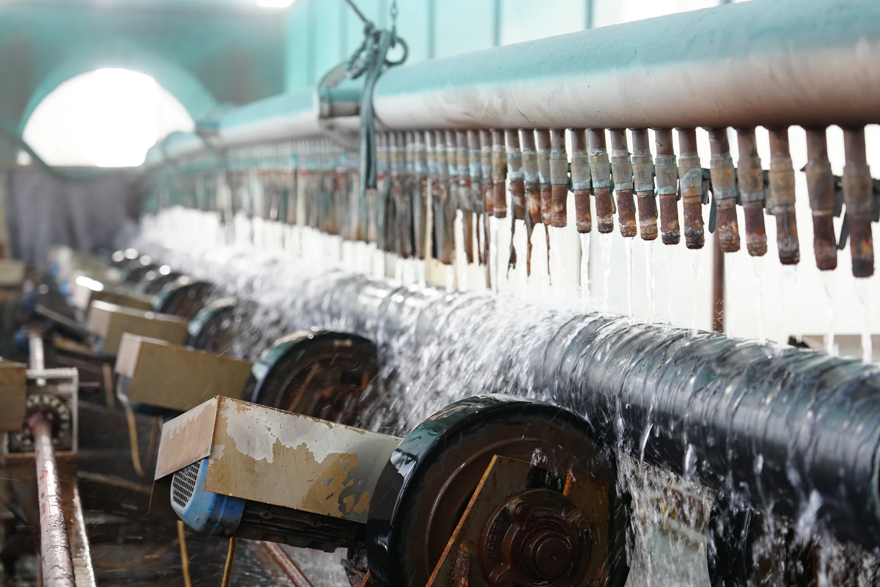 Water-spray cooling rollers for coated steel pipes
